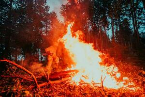 firefighter hero in action danger jumping over fire flame to rescue and save photo