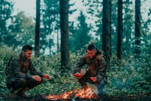 Two exhausted soldiers sitting by the fire after a weary and heavy war battle photo