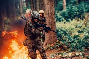 Soldier in Action at Night in the Forest Area. Night Time Military Mission jumping over fire photo