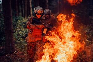 Soldier in Action at Night in the Forest Area. Night Time Military Mission jumping over fire photo