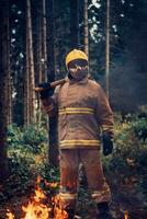 Firefighter at job. Firefighter in dangerous forest areas surrounded by strong fire. Concept of the work of the fire service photo