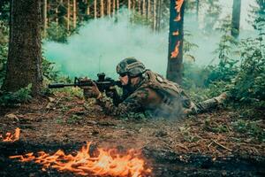 Modern warfare soldier surrounded by fire, fight in dense and dangerous forest areas photo