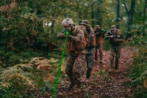 A group of modern warfare soldiers is fighting a war in dangerous remote forest areas. A group of soldiers is fighting on the enemy line with modern weapons. The concept of warfare and military conflicts photo