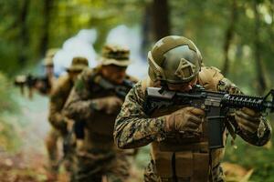 A group of modern warfare soldiers is fighting a war in dangerous remote forest areas. A group of soldiers is fighting on the enemy line with modern weapons. The concept of warfare and military conflicts photo