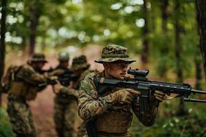 A group of modern warfare soldiers is fighting a war in dangerous remote forest areas. A group of soldiers is fighting on the enemy line with modern weapons. The concept of warfare and military conflicts photo