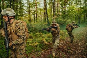 A group of modern warfare soldiers is fighting a war in dangerous remote forest areas. A group of soldiers is fighting on the enemy line with modern weapons. The concept of warfare and military conflicts photo