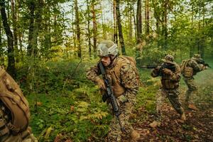 A group of modern warfare soldiers is fighting a war in dangerous remote forest areas. A group of soldiers is fighting on the enemy line with modern weapons. The concept of warfare and military conflicts photo