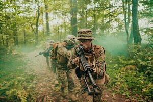 A group of modern warfare soldiers is fighting a war in dangerous remote forest areas. A group of soldiers is fighting on the enemy line with modern weapons. The concept of warfare and military conflicts photo