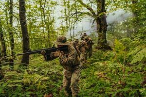 A group of modern warfare soldiers is fighting a war in dangerous remote forest areas. A group of soldiers is fighting on the enemy line with modern weapons. The concept of warfare and military conflicts photo