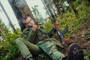 Terrorist have a break and smoke cigarette in forest during battle photo