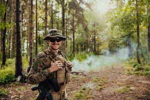 Soldier portrait with protective army tactical gear and weapon having a break and relaxing photo