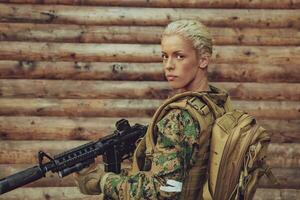 Woman soldier ready for battle wearing protective military gear and weapon photo