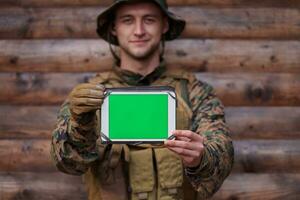 soldado que usa una tableta en un campamento militar foto