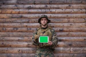 soldado que usa una tableta en un campamento militar foto