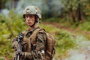 Woman soldier ready for battle wearing protective military gear and weapon photo