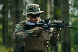 soldier in action aiming  on weapon  laser sight optics photo