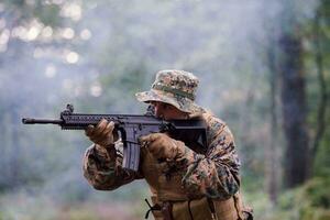 soldier in action aiming  on weapon  laser sight optics photo