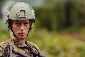 Woman soldier ready for battle wearing protective military gear and weapon photo