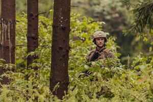 un moderno guerra soldado en guerra deber en denso y peligroso bosque áreas peligroso militar rescate operaciones foto