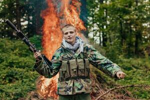Angry terrorist militant guerrilla soldier warrior in forest photo