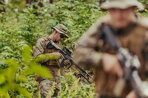 un grupo de moderno guerra soldados es luchando un guerra en peligroso remoto bosque áreas un grupo de soldados es luchando en el enemigo línea con moderno armas el concepto de guerra y militar conflictos foto