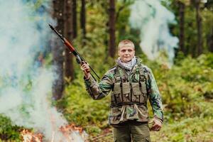 Angry terrorist militant guerrilla soldier warrior in forest photo