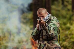 Angry terrorist militant guerrilla soldier warrior in forest photo