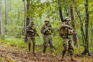 A group of modern warfare soldiers is fighting a war in dangerous remote forest areas. A group of soldiers is fighting on the enemy line with modern weapons. The concept of warfare and military conflicts photo