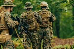 A group of modern warfare soldiers is fighting a war in dangerous remote forest areas. A group of soldiers is fighting on the enemy line with modern weapons. The concept of warfare and military conflicts photo