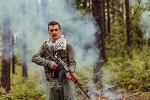 Angry terrorist militant guerrilla soldier warrior in forest photo