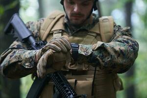 soldier preparing tactical and commpunication gear for action battle photo