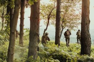 A group of modern warfare soldiers is fighting a war in dangerous remote forest areas. A group of soldiers is fighting on the enemy line with modern weapons. The concept of warfare and military conflicts photo