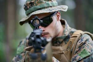 soldier in action aiming  on weapon  laser sight optics photo