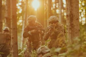 A group of modern warfare soldiers is fighting a war in dangerous remote forest areas. A group of soldiers is fighting on the enemy line with modern weapons. The concept of warfare and military conflicts photo