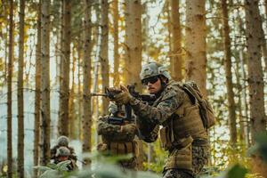 A group of modern warfare soldiers is fighting a war in dangerous remote forest areas. A group of soldiers is fighting on the enemy line with modern weapons. The concept of warfare and military conflicts photo