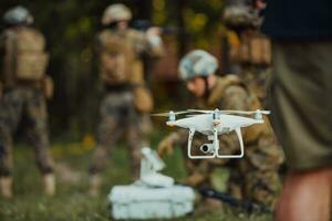 Modern Warfare Soldiers Squad are Using Drone for Scouting and Surveillance During Military Operation in the Forest. photo