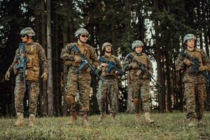 Soldier fighters standing together with guns. Group portrait of US army elite members, private military company servicemen, anti terrorist squad photo