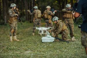 Modern Warfare Soldiers Squad are Using Drone for Scouting and Surveillance During Military Operation in the Forest. photo