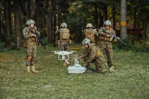 Modern Warfare Soldiers Squad are Using Drone for Scouting and Surveillance During Military Operation in the Forest. photo