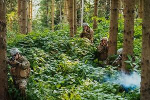 A group of modern warfare soldiers is fighting a war in dangerous remote forest areas. A group of soldiers is fighting on the enemy line with modern weapons. The concept of warfare and military conflicts photo