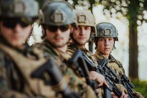 Soldier fighters standing together with guns. Group portrait of US army elite members, private military company servicemen, anti terrorist squad photo