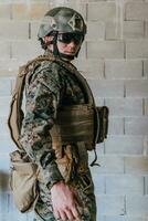 un soldado en uniforme soportes en frente de un Roca pared en lleno guerra engranaje preparando para batalla foto