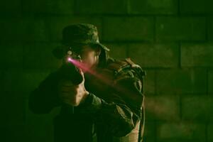 soldier in action aiming  on laser sight optics photo