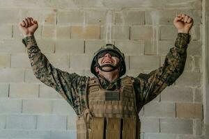 éxito en el guerra campaña. un soldado con elevado manos celebra el exitoso conquista de enemigo territorio foto