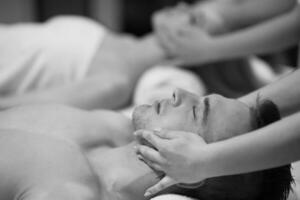 couple enjoying head massage at the spa photo