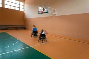 Disabled War veterans mixed race opposing basketball teams in wheelchairs photographed in action while playing an important match in a modern hall. photo