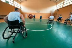 Disabled War veterans mixed race and age basketball teams in wheelchairs playing a training match in a sports gym hall. Handicapped people rehabilitation and inclusion concept photo
