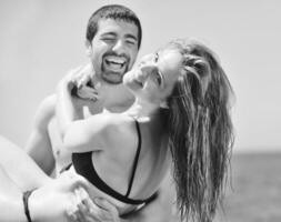 feliz pareja joven tiene tiempo romántico en la playa foto