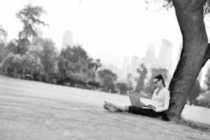 mujer con laptop en el parque foto