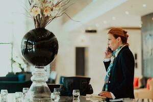 Photo of an elderly woman using a smartphone to carry out business projects and tasks in a modern corporation